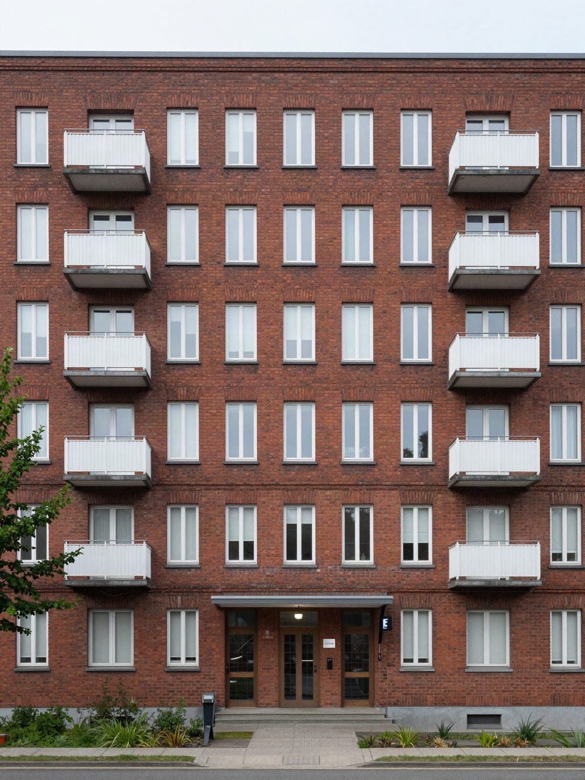Symbolbild: Mehrfamilienhaus aus Backstein mit Balkonen